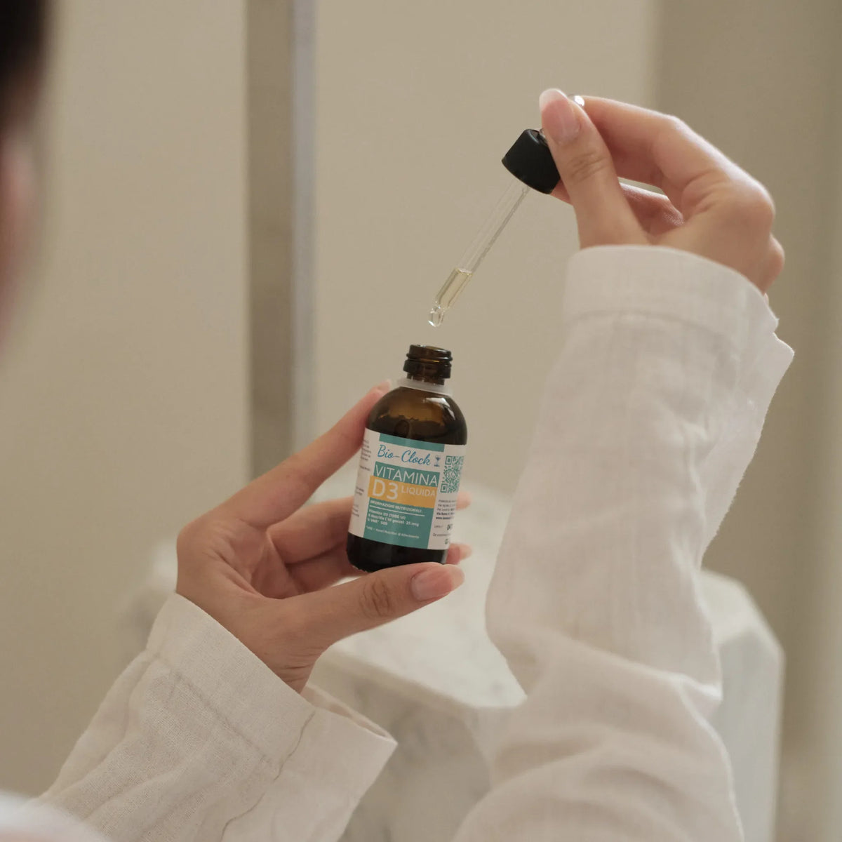 Vitamina D3 - Liquida 1000 UI — flacone nelle mani durante l’utilizzo.